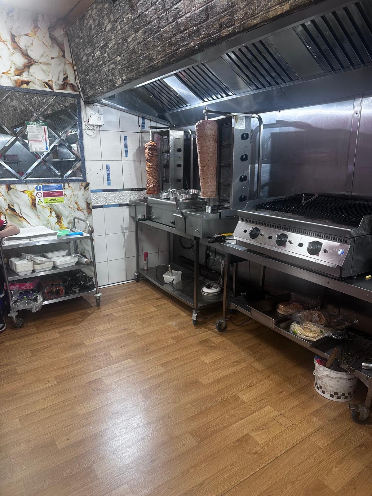 Kitchen — shawarma spits and charcoal grill in action